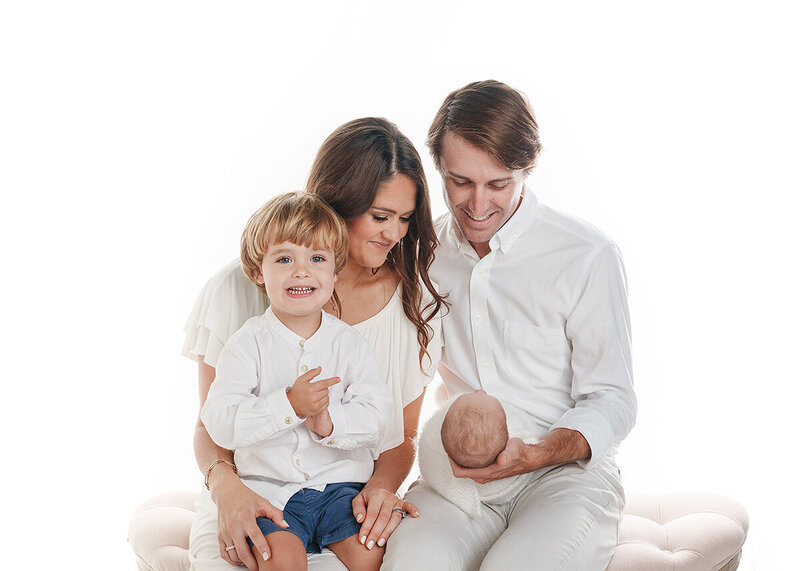 newborn and family photographed in studio during a newborn session on a bright white background