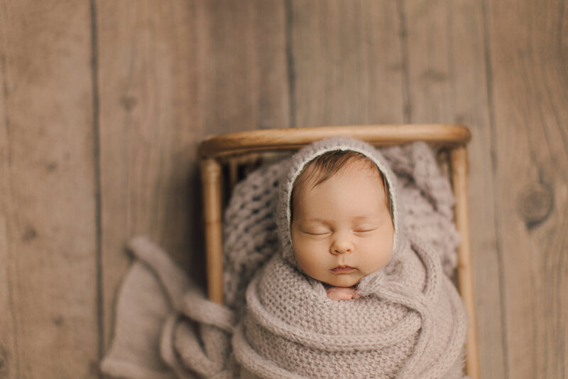 newborn photos of baby in purple wrap