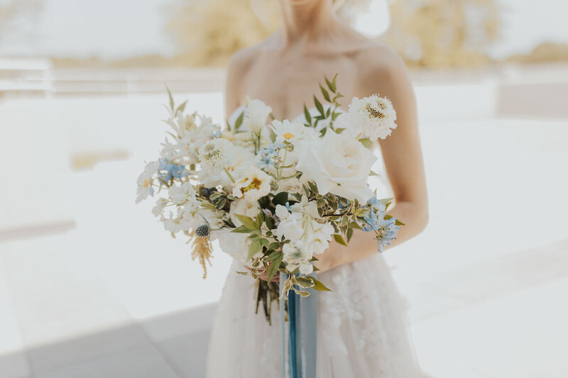 Bride holding bouquet designed by Raleigh wedding planners