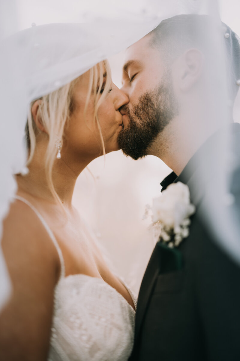 Bride and groom kissing under a veil after their wedding at Woodberry in Havana, Florida near Tallahassee.
