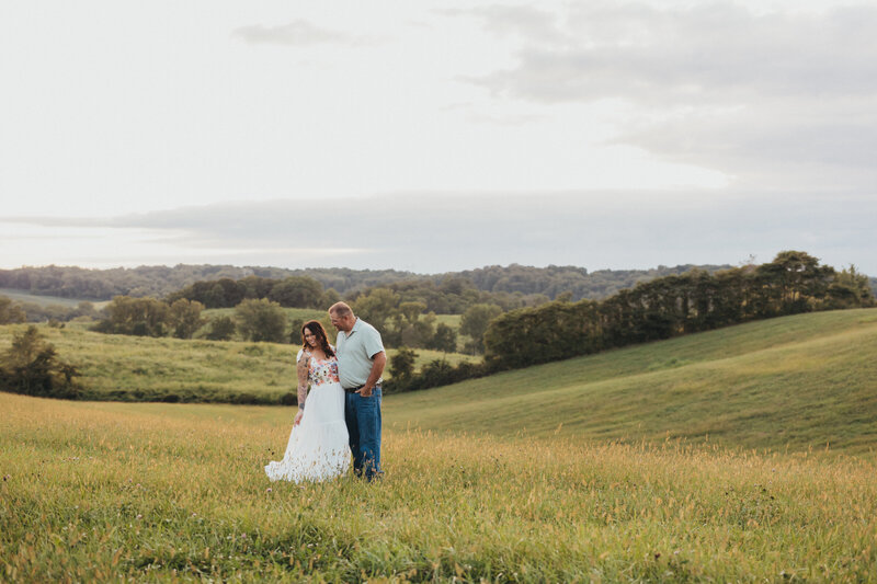 couple standing in a field all snuggled up in love 