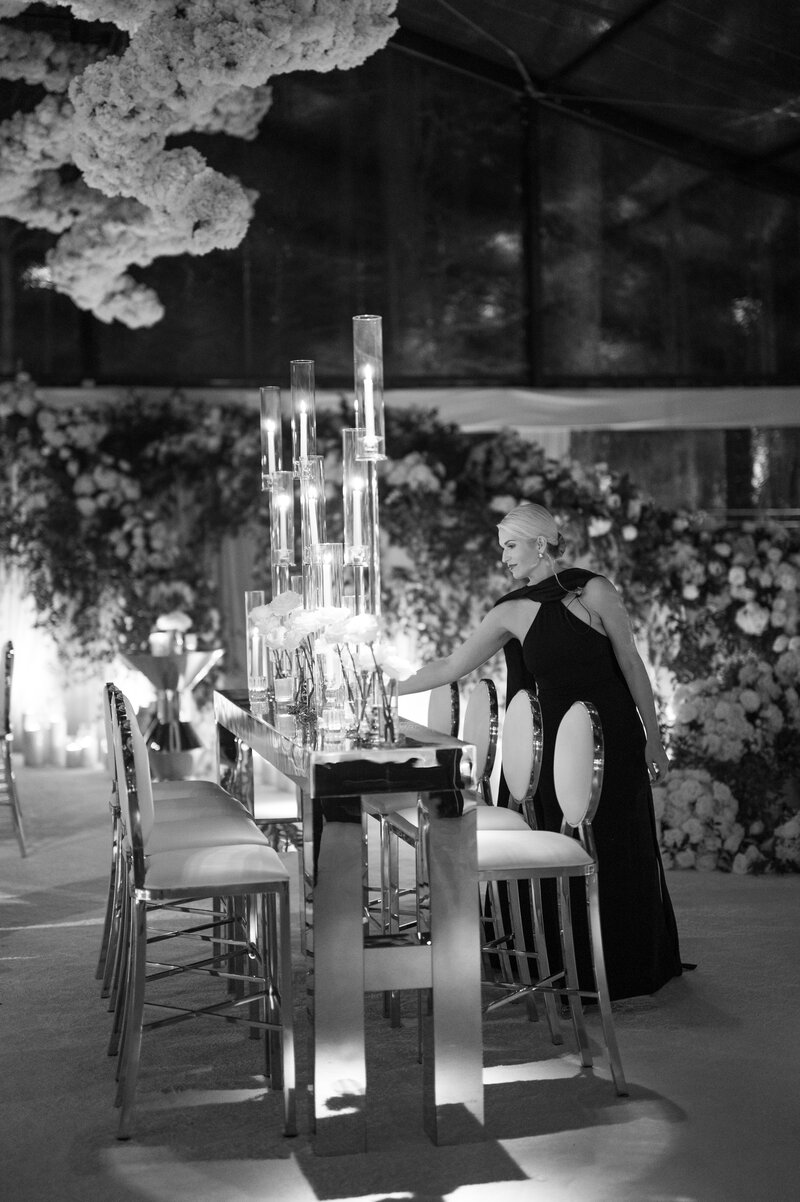 Wedding planner Tori Perano sets a table at a wedding reception.