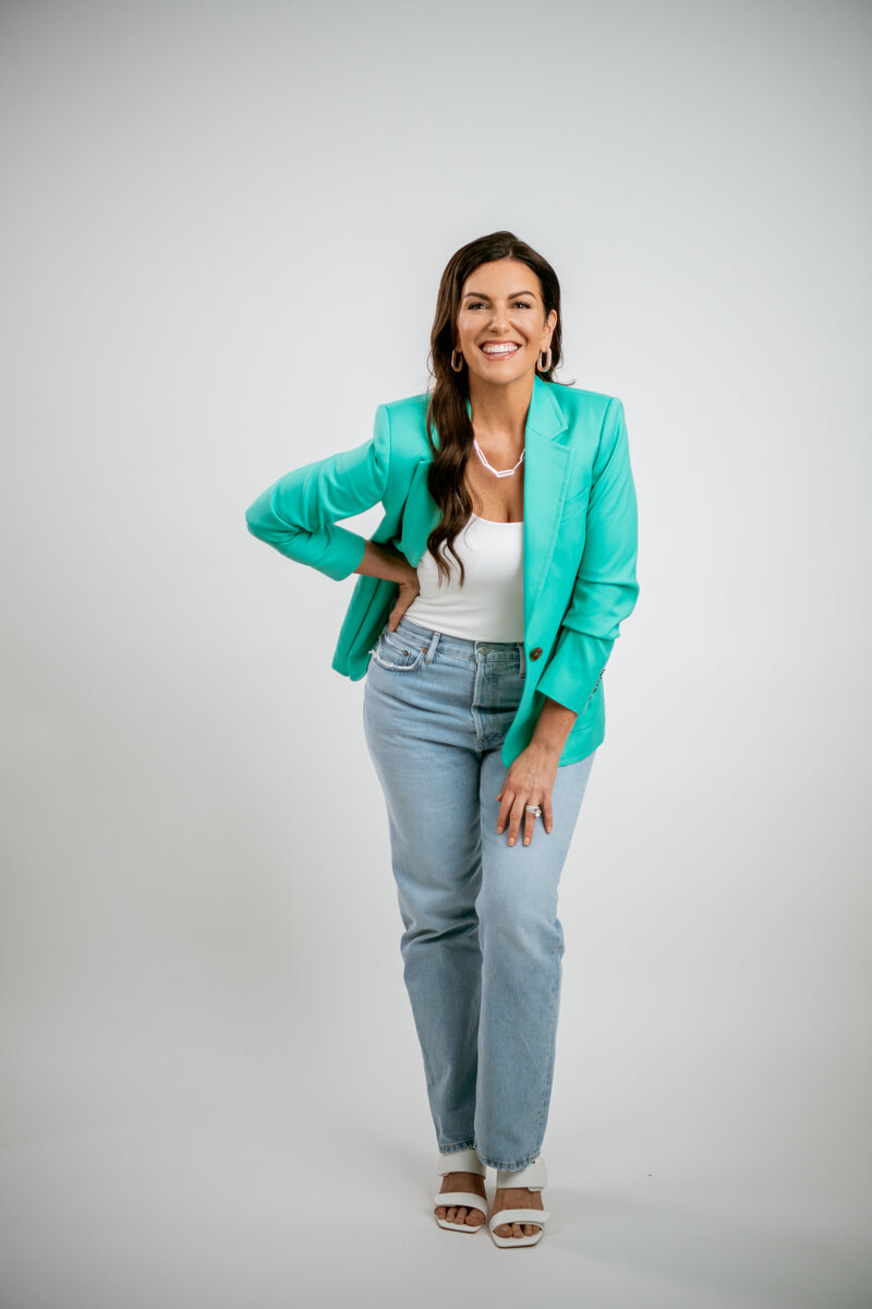 Amy Porterfield Headshot in Teal Jacket and Pointing - Online Marketing Expert