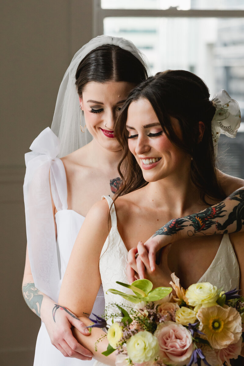 Two brides holding each other during Calgary elopement