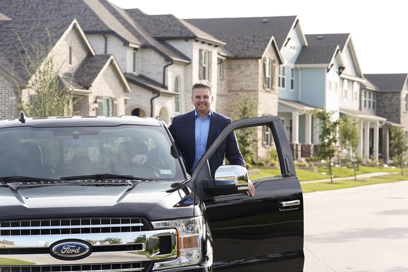 Jason Sickles exiting his car in a luxurious neighborhood.