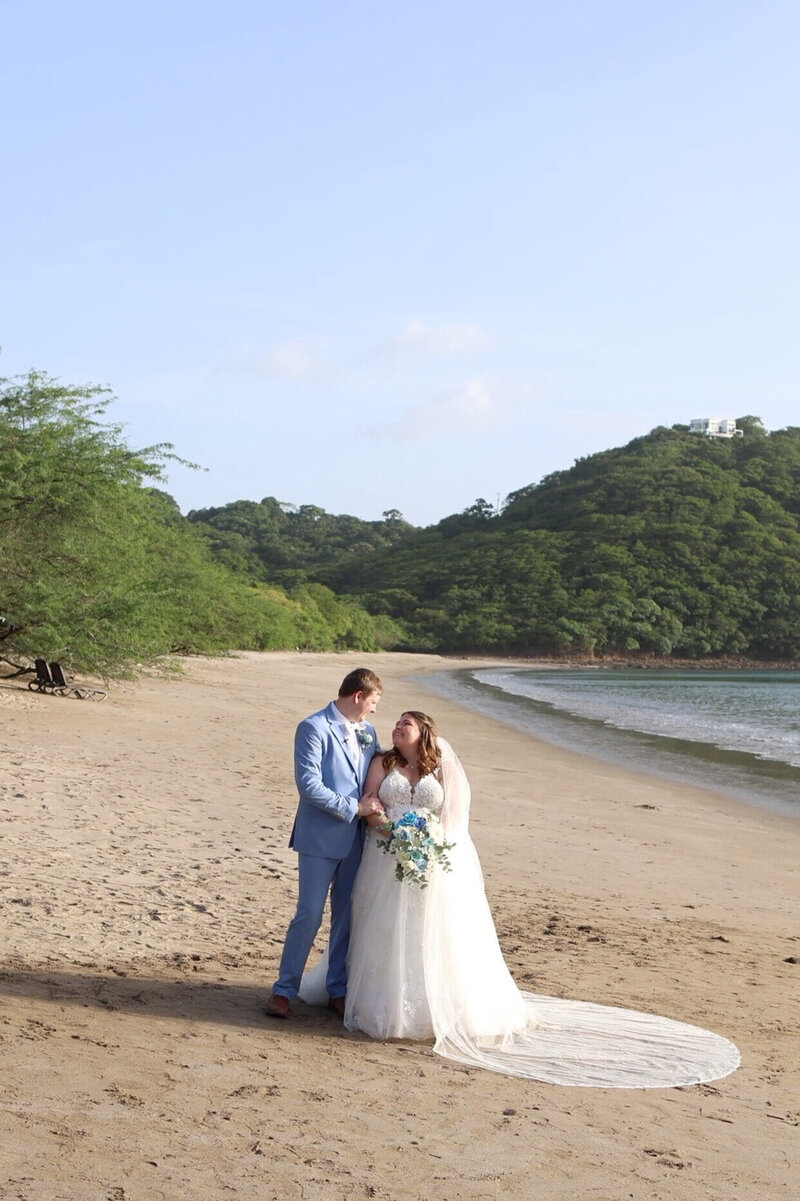 Bride and Groom embracing on the beach at Dreams Las Mareas 