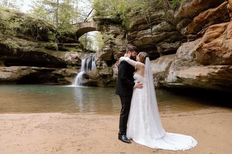 Couple embracing each other in front of the waterfall in Old Man's Cave at Hocking Hills.