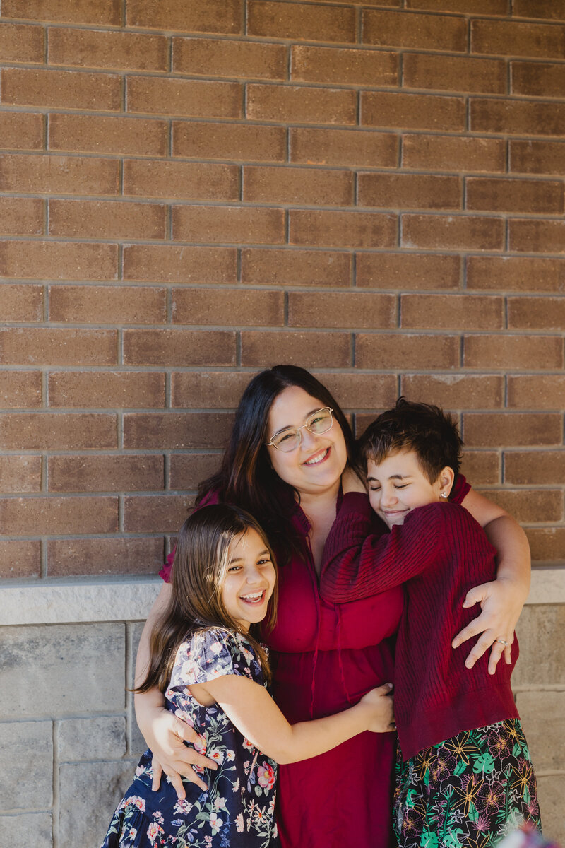 Valerie Doucette, Ottawa and Gatineau Branding Photographer, hugging her daughters with smiles on their faces