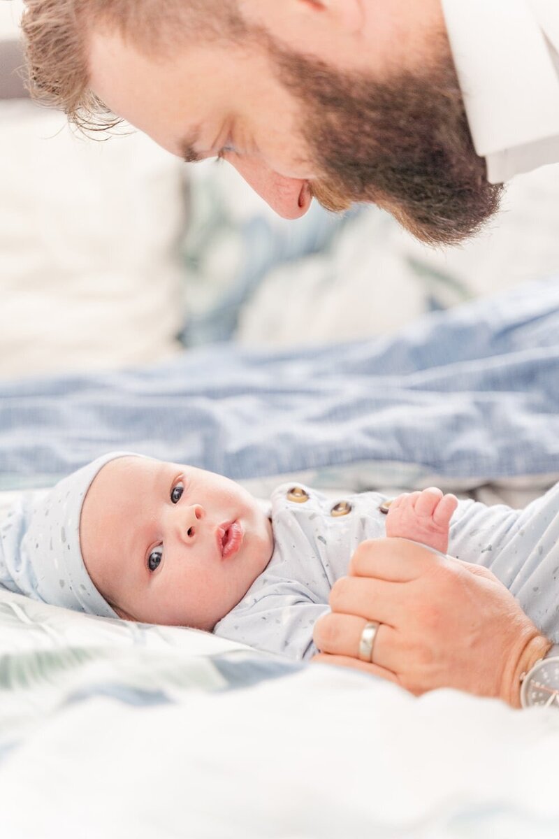 dad looking at baby in Gainesville, VA taken by a lifestyle newborn photographer in Northern Virginia