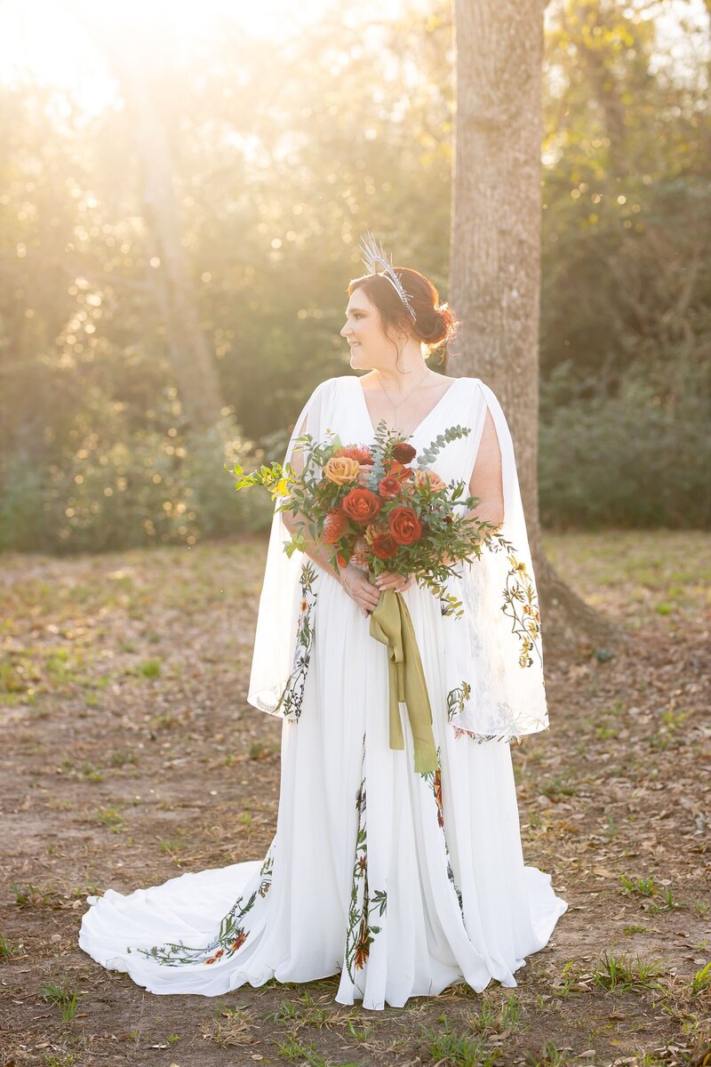 Bride wearing crown holding red and orange bouquet