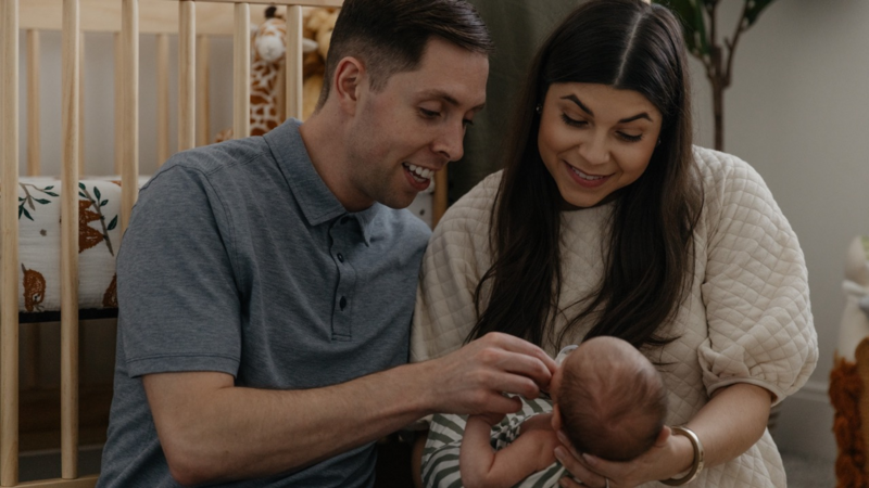 Young Parents Holding Newborn in Nursery