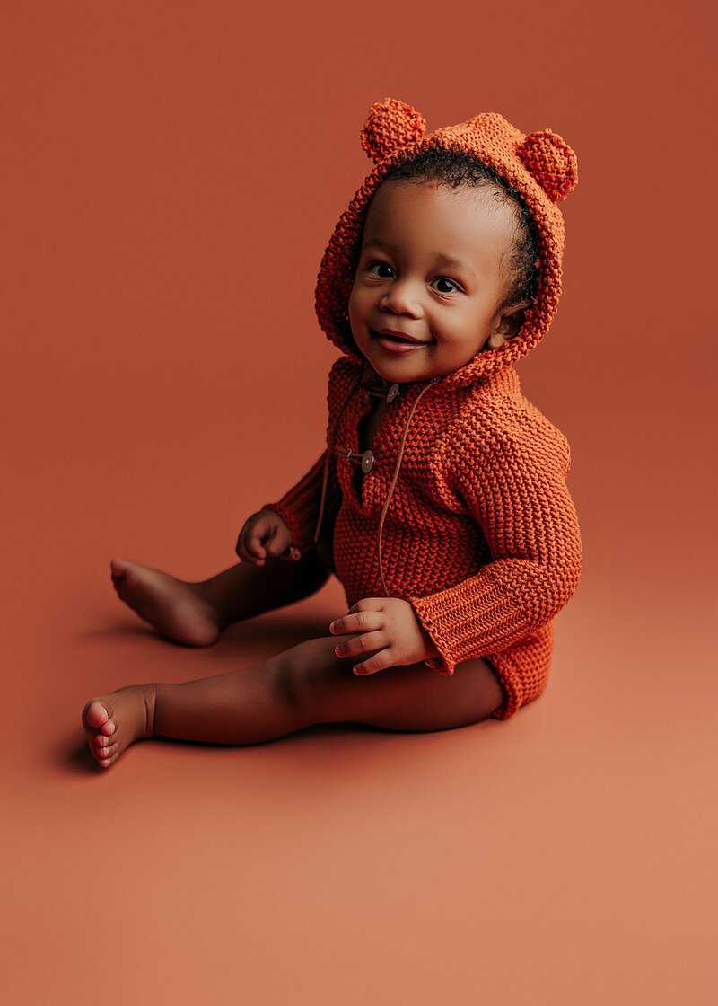 Baby sticking out tongue in cheeky milestone portrait