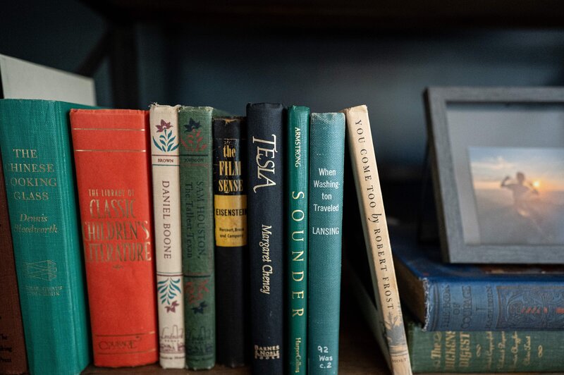 Collection of colorful vintage books styled neatly on a bookshelf — classic staging detail for Williamsburg homes.