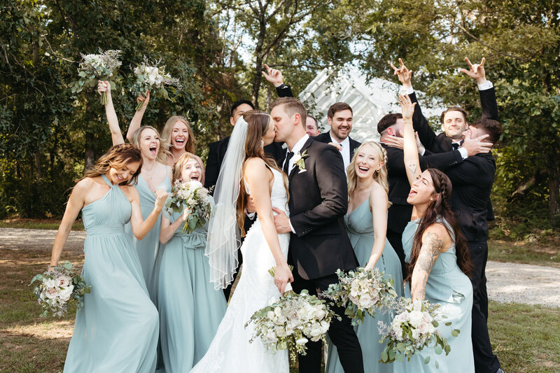 wedding couple celebrating with bridal party at kindred barn wedding venue.