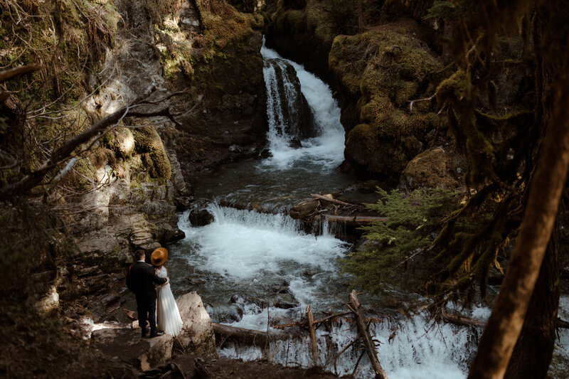 bride and groom near waterfall