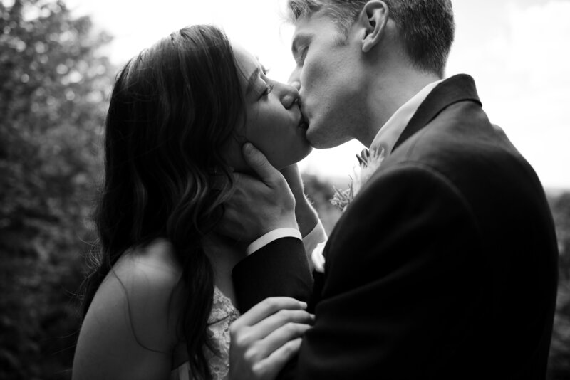 Ohio bride  in a white wedding dress and groom in a black tux, embrace and start to kiss in Cuyahoga Valley National Park on their wedding day. Photographed by Columbus wedding photographer Aaron Aldhizer