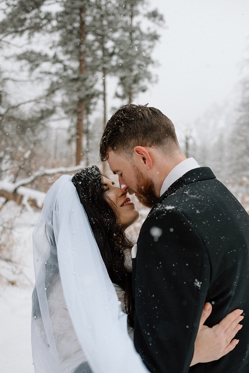 bride and groom embrace in the snowy Colorado mountains