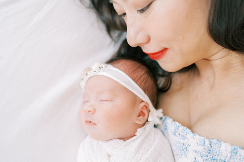 mom laying in bed with newborn baby girl 