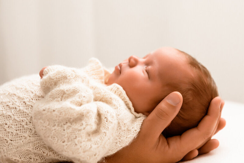 mother embracing her newborn son at photoshoot