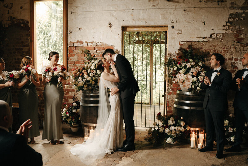 bride and groom sharing their first kiss at their ceremony Euroa Butter Factory
