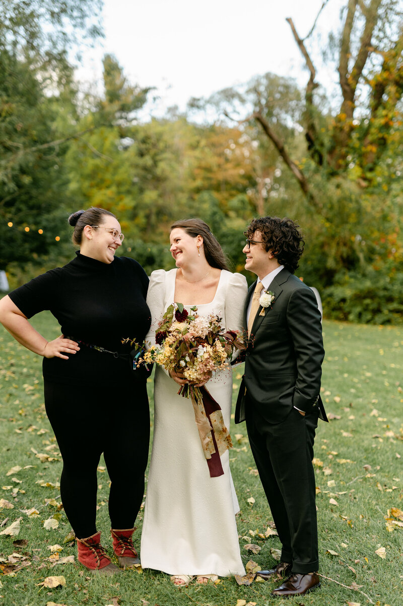 Rachel smiling with bride and groom she helped with their wedding