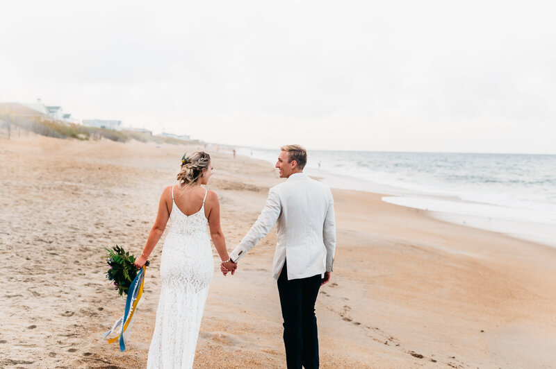 bride and groom walking on the beach in southern shores, nc