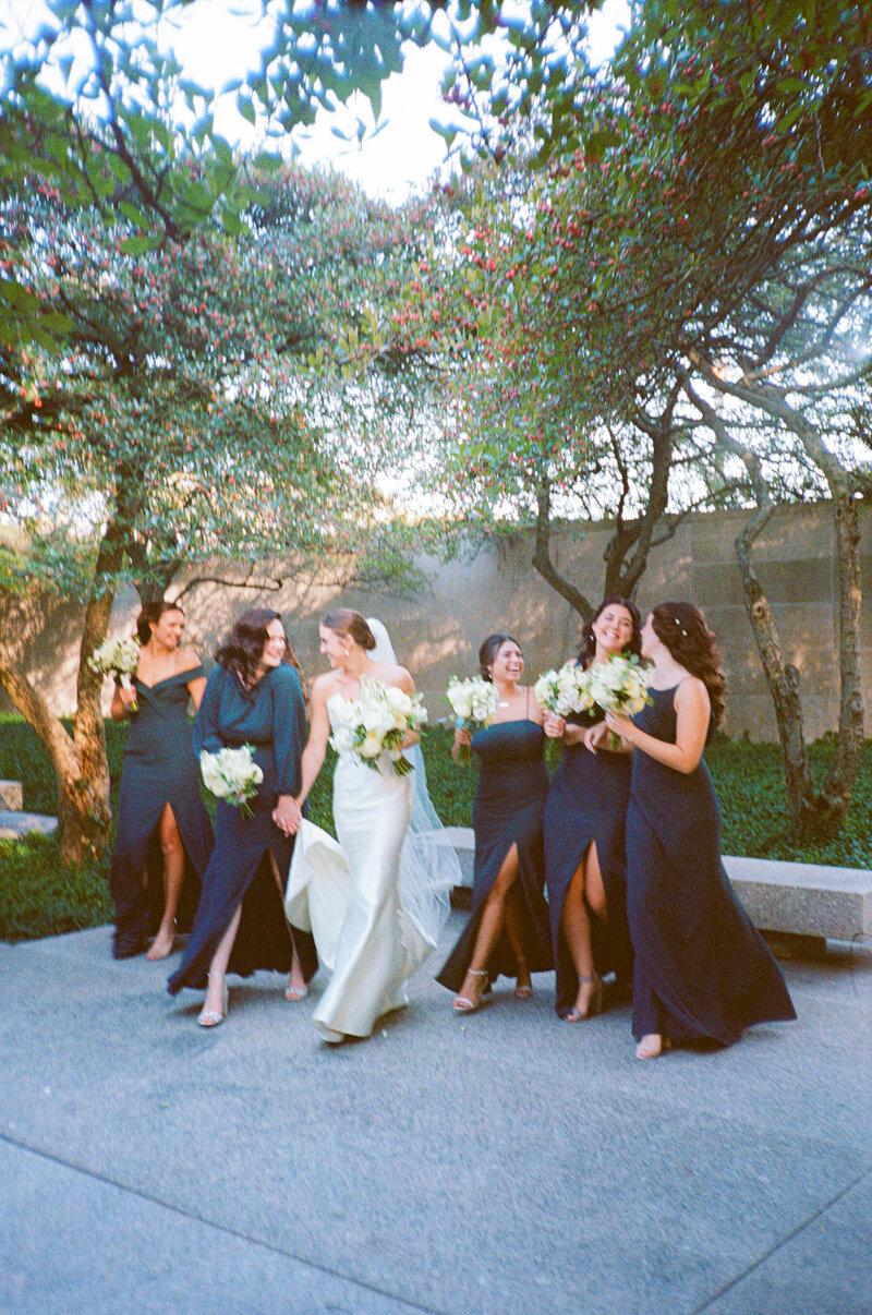 A bride and her bridesmaids share a moment at the Art Institute in Chicago, captured on film