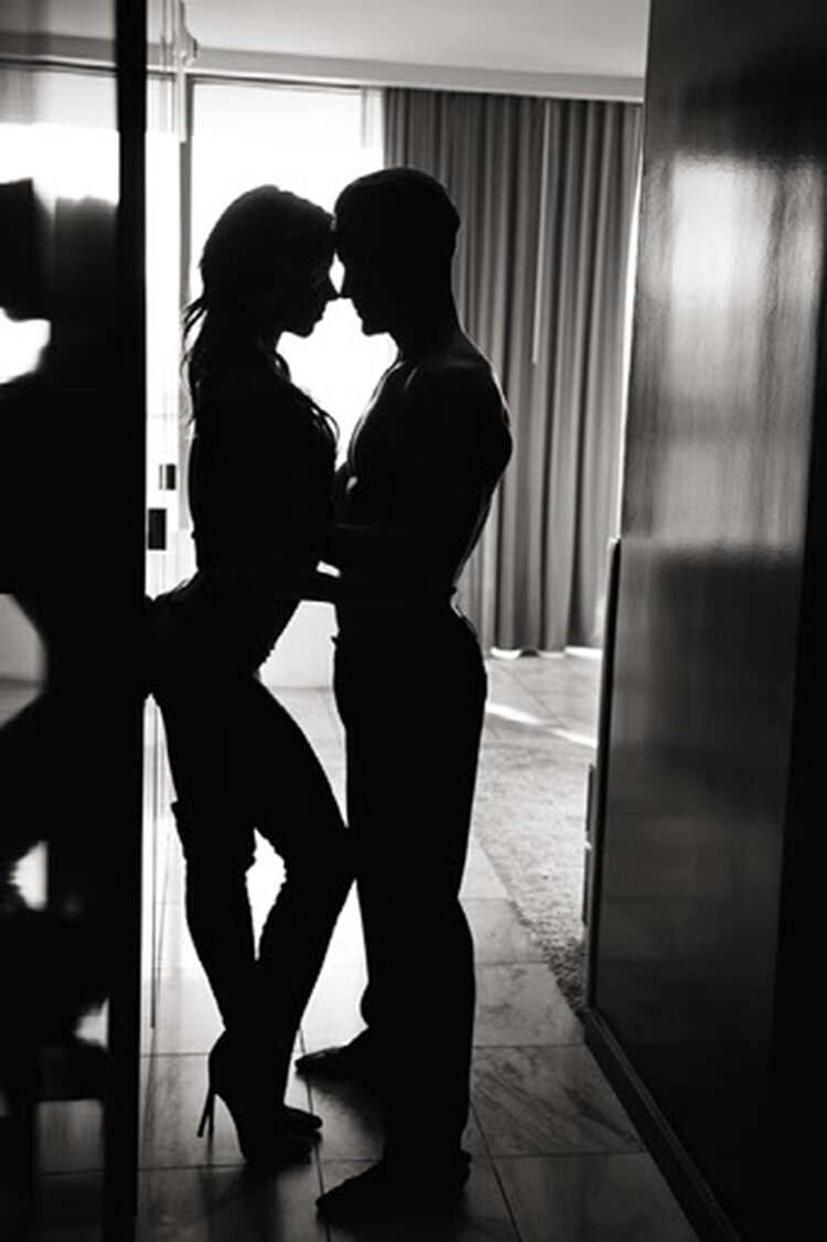 Black and white couples portrait of couple embracing on the floor in the desert