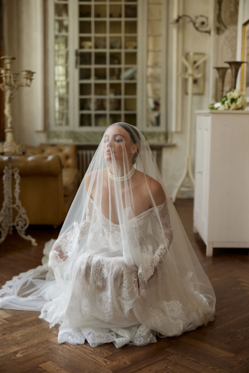 bride wearing white lace wedding dress with long veil