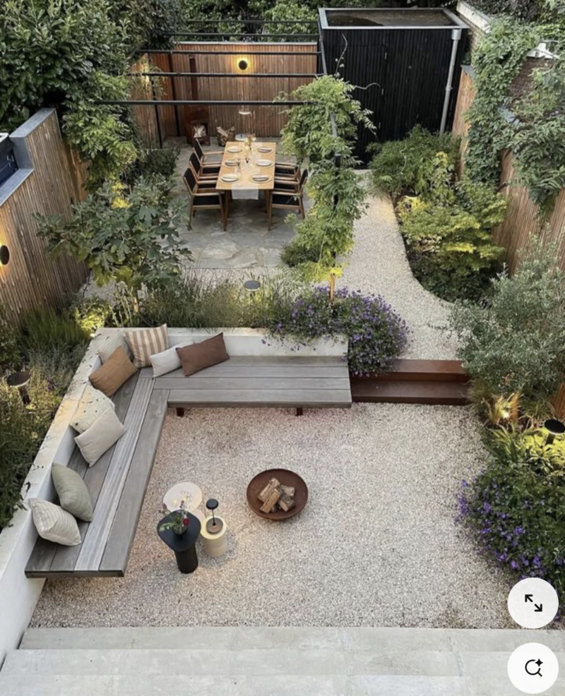 Oversiktsbilde fra en bakgård med planter, benker og lys. 