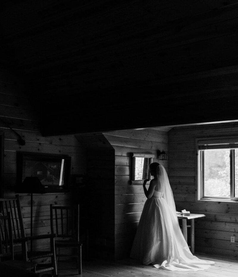 A bride enjoys a quiet moment in a cabin as she gets ready for her mountain elopement in Washington