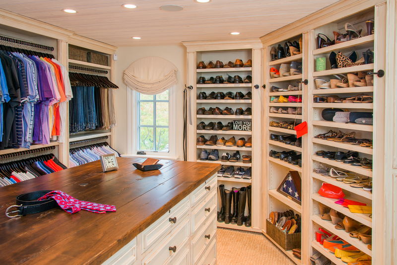 Custom designed closet with built-in shoe storage, shelves and center island with drawers