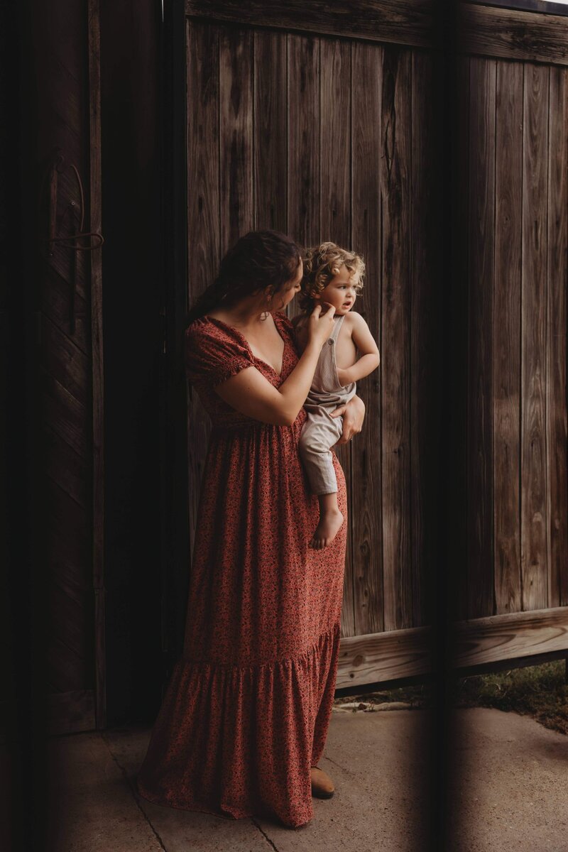 Mother holding toddler on his hip during a candid family photoshoot