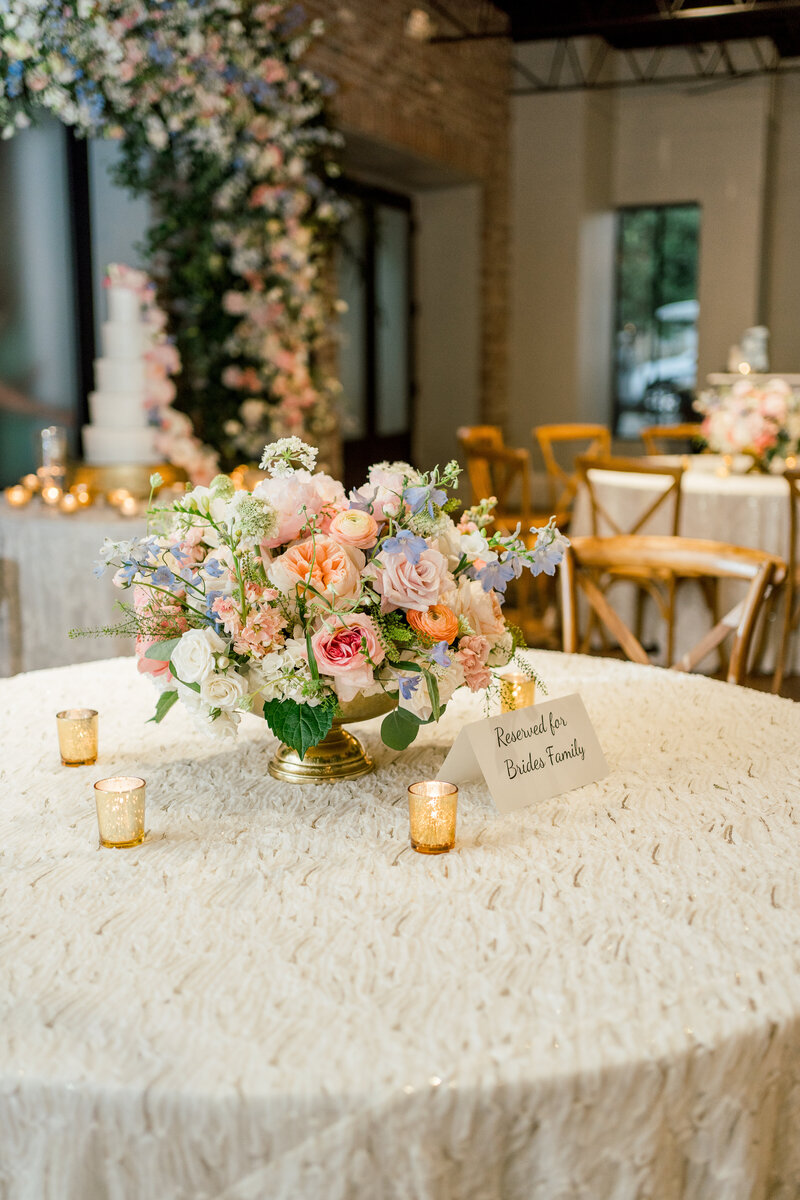 a table decorated with a lace tablecloth and flower arrangement