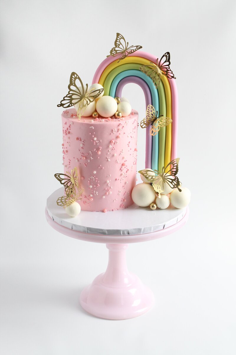 Pink cake with frosting and gold butterflies