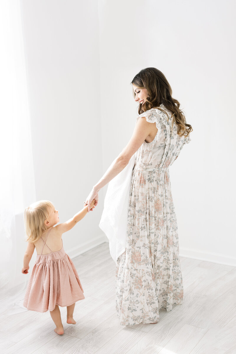 Mom and toddler holding hands