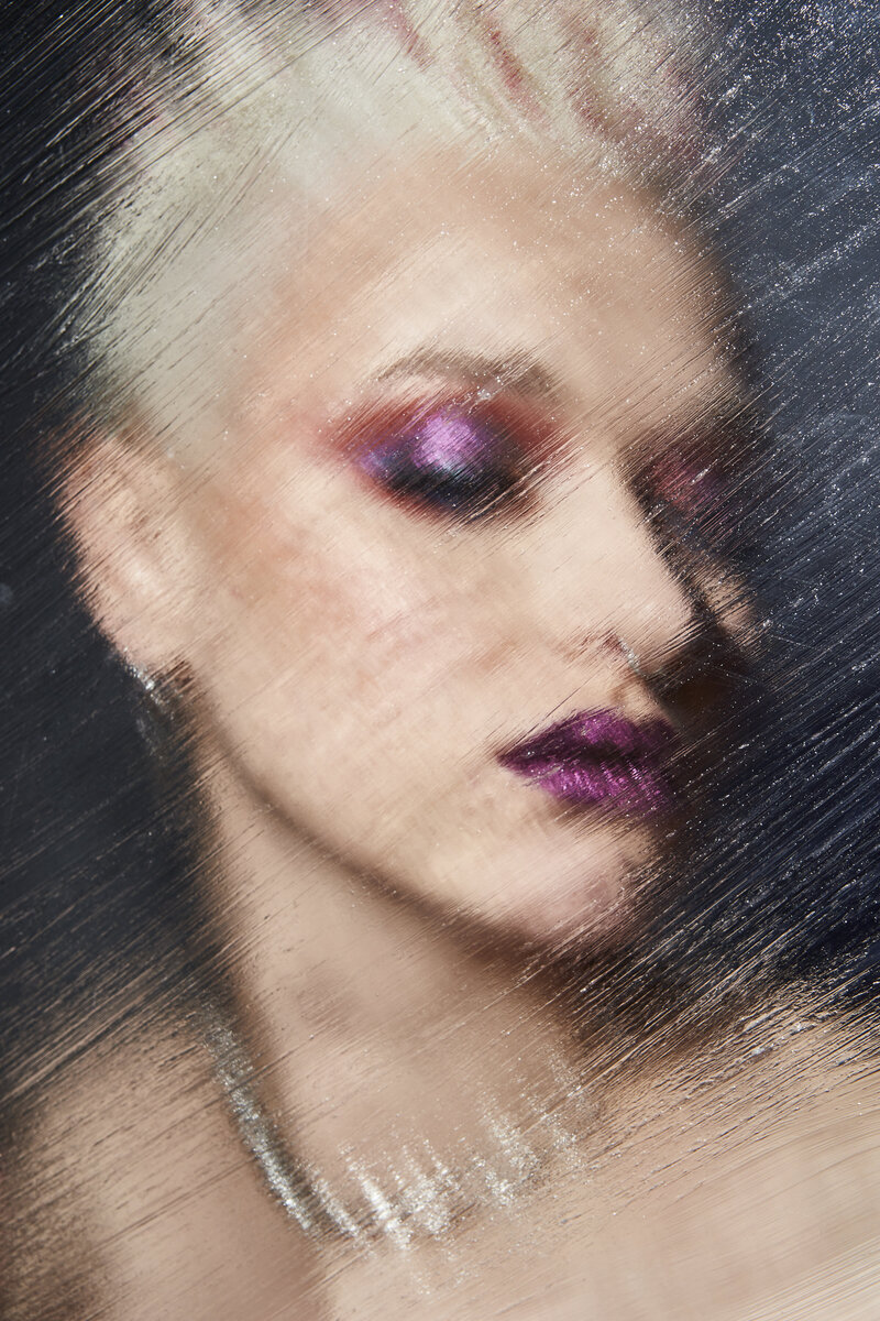 Striking portrait of Ivanka with glittering makeup and wet hair, captured by Ylva Erevall in bold lighting.