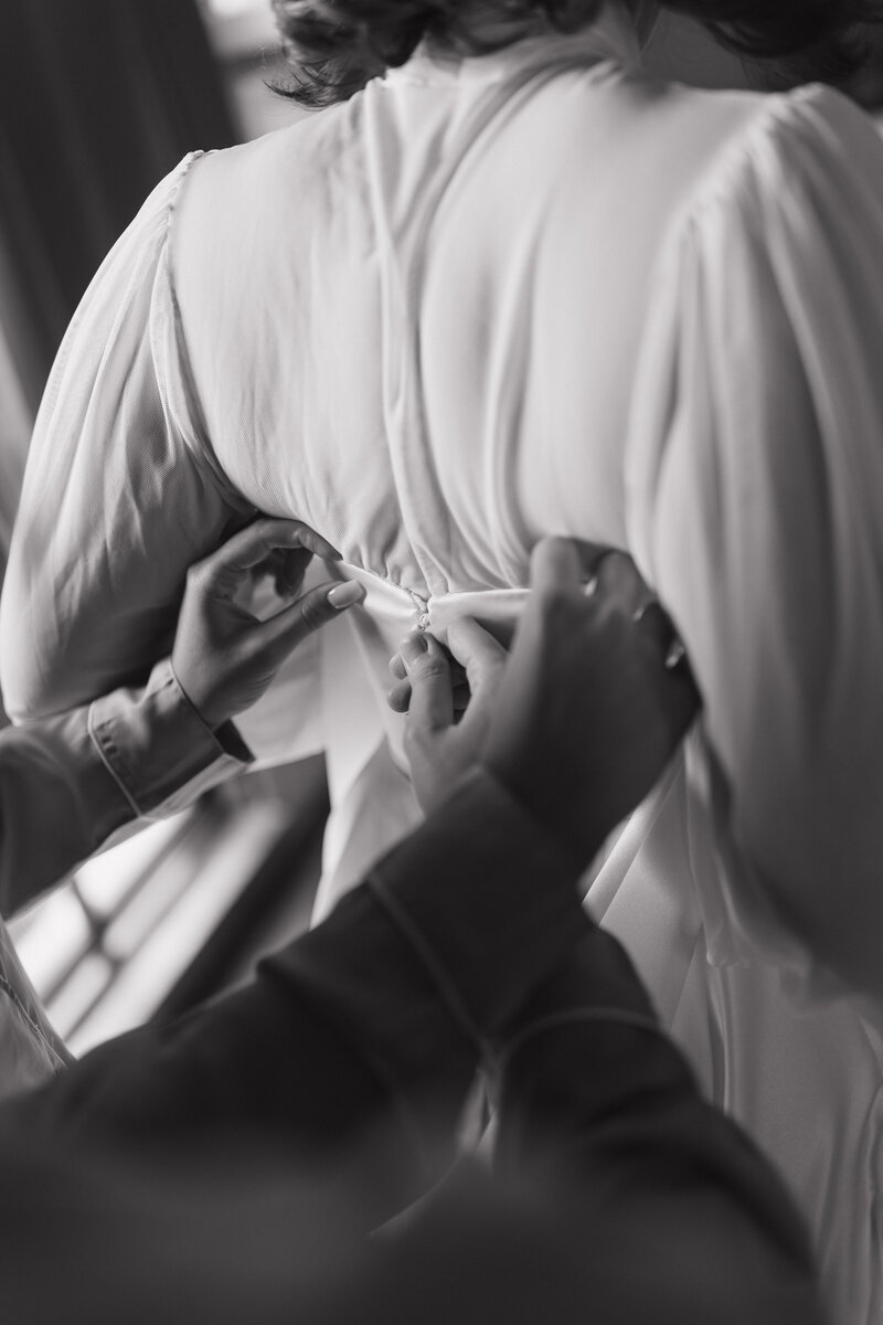 An elegant fine art black and white portrait of a bride getting ready, highlighting soft textures, delicate light, and editorial-style composition.