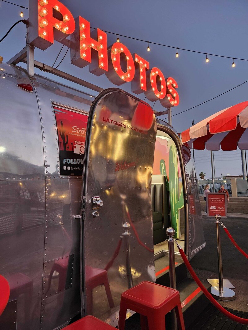 Phoenix Arizona Vintage Airstream Photo Booth at corporate event at The Duce with red "Photos" sign glowing at night