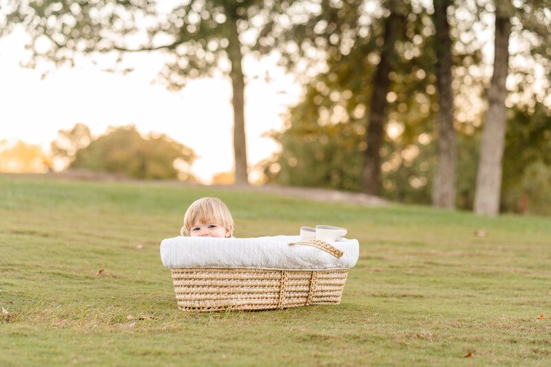 Chattanooga photographer took portrait of toddler big brother in moses basket during newborn photography session.