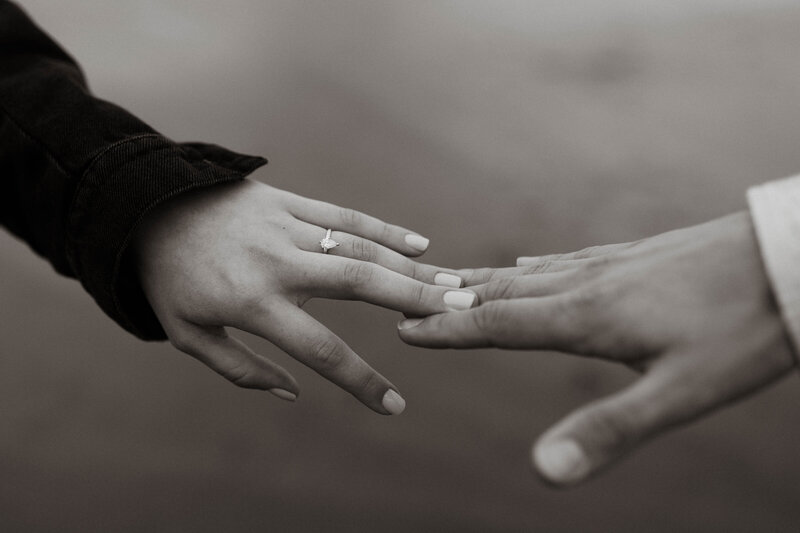 Couple touching hands focus on engagement ring