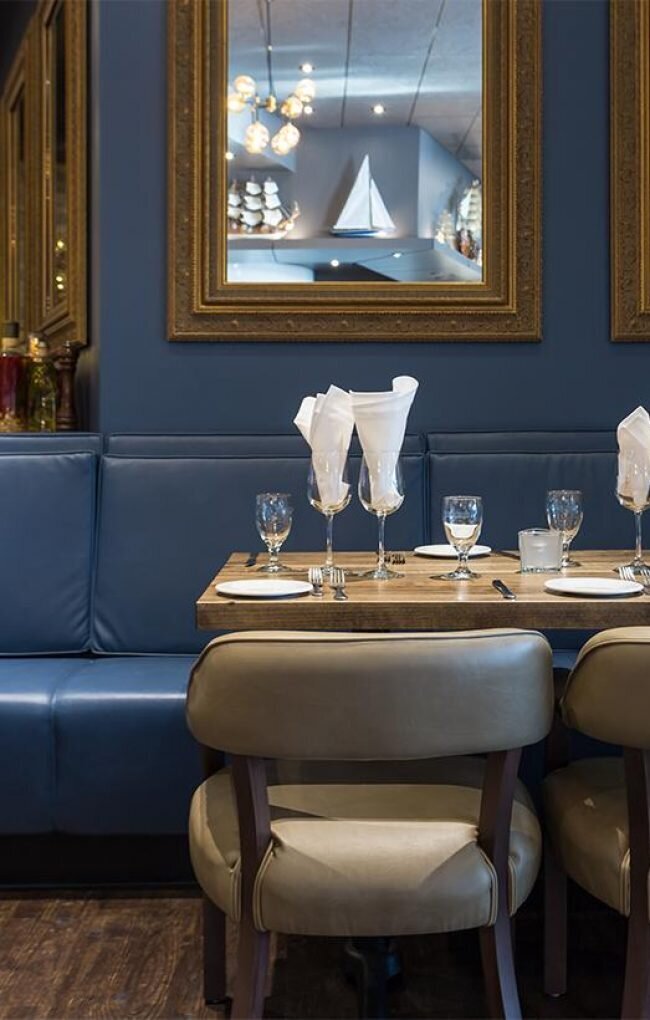 Interior of Trattoria Timone, high end italic restaurant with rich blue walls and bench seats