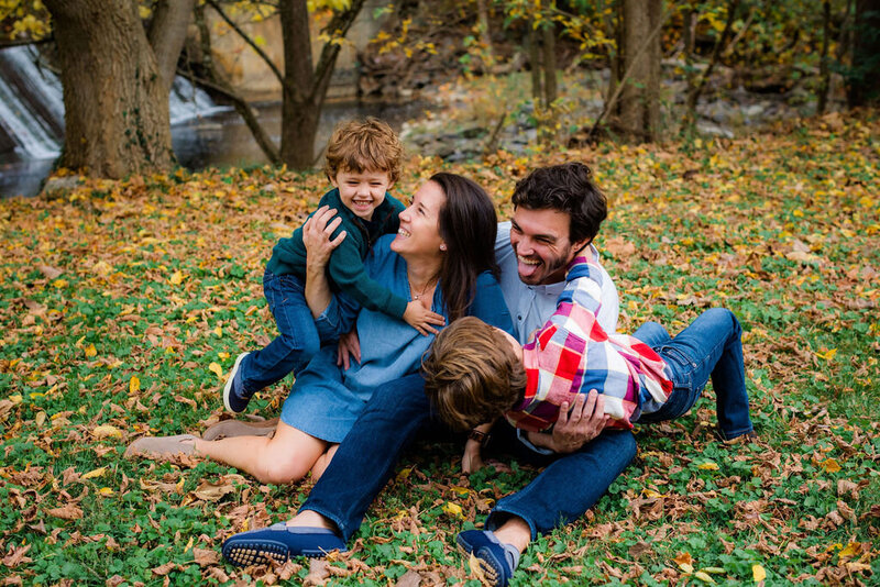 Parents laying in the grass playing with their children