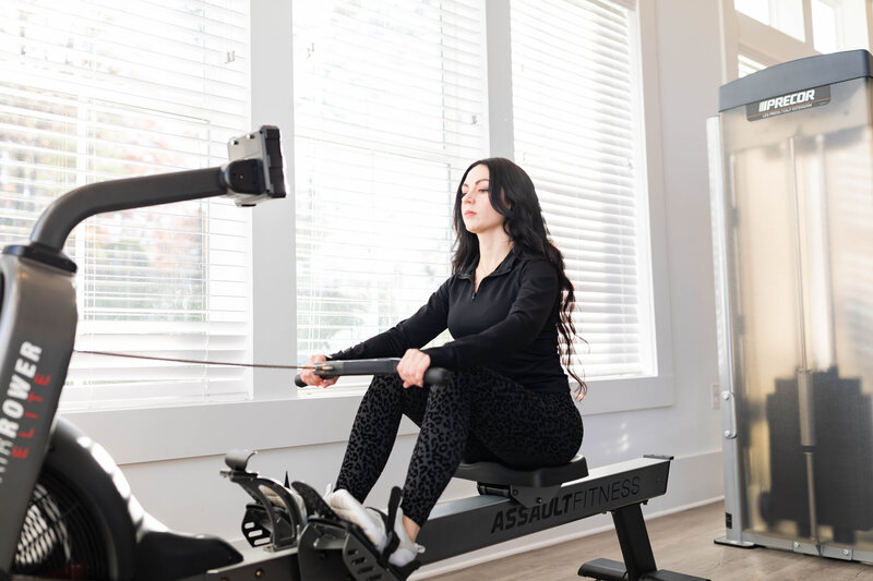 Fitness coach based in South Caroline  poses on rowing machine.
