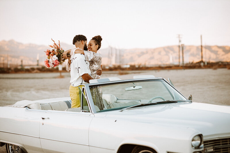 bride and groom stand in car