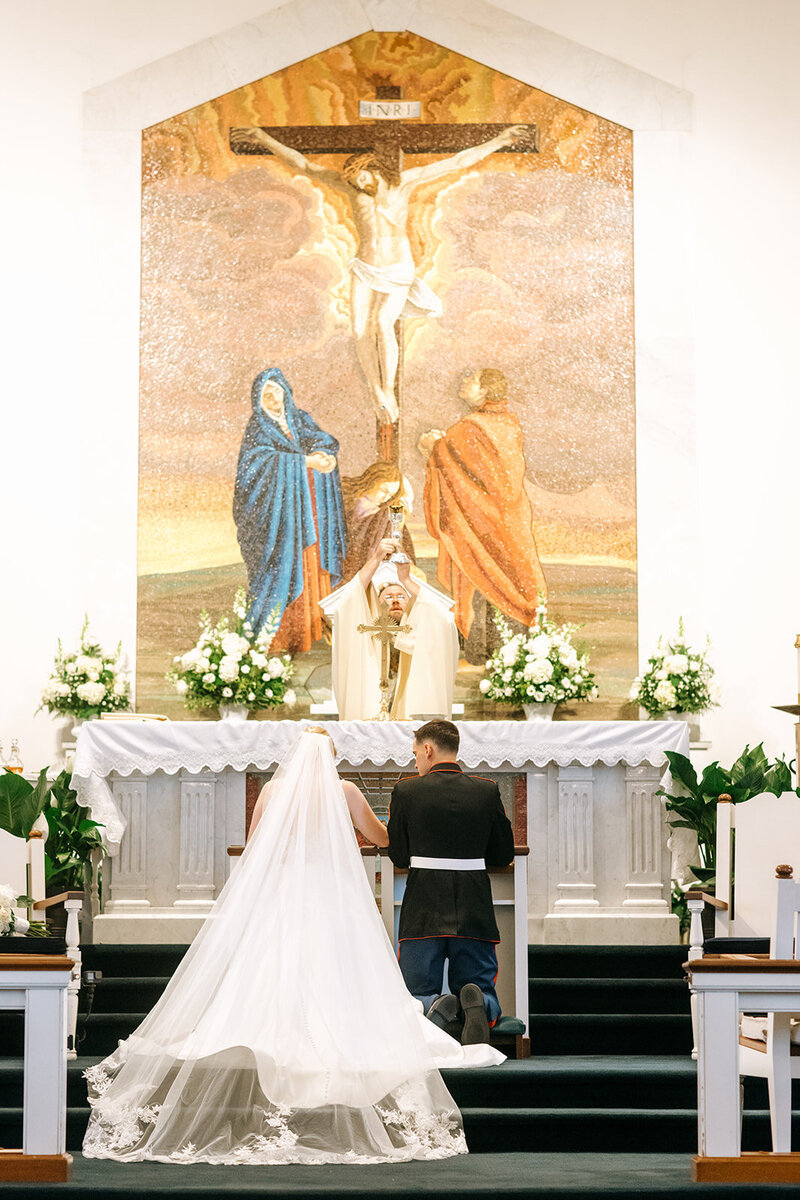 bride and groom kneeling at church altar