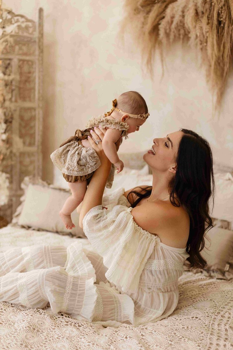 in a studio shoot while mother carrying high up her daugther