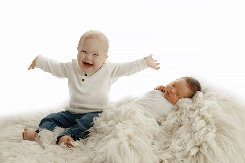 boy with down syndrome excited about being a big brother at claremore newborn session