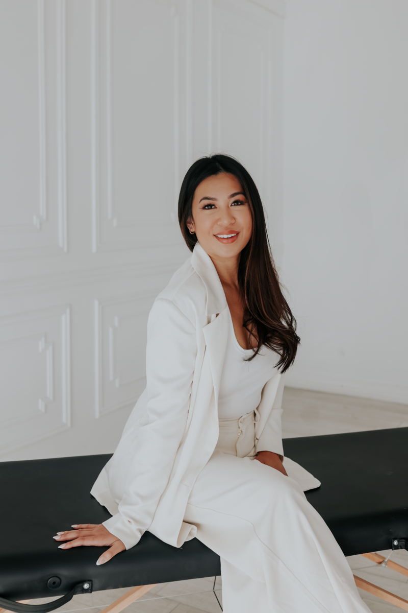woman in white suit sitting and smiling