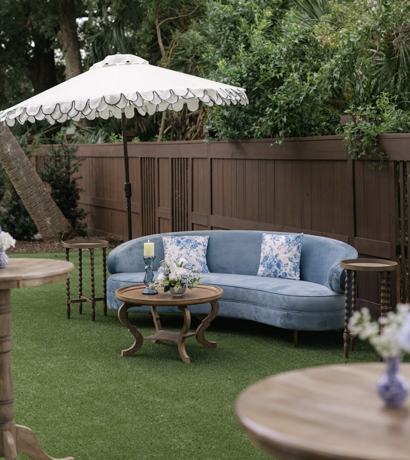 LUXE Belle curved slate-blue velvet sofa styled in an outdoor lounge